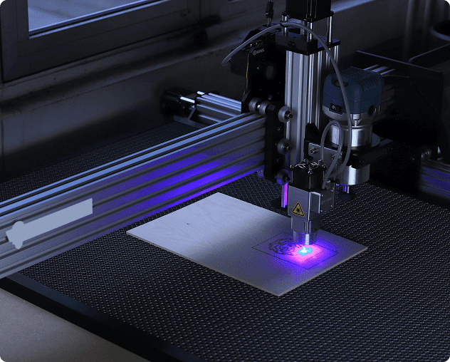 Laser engraving machine on a wooden surface.