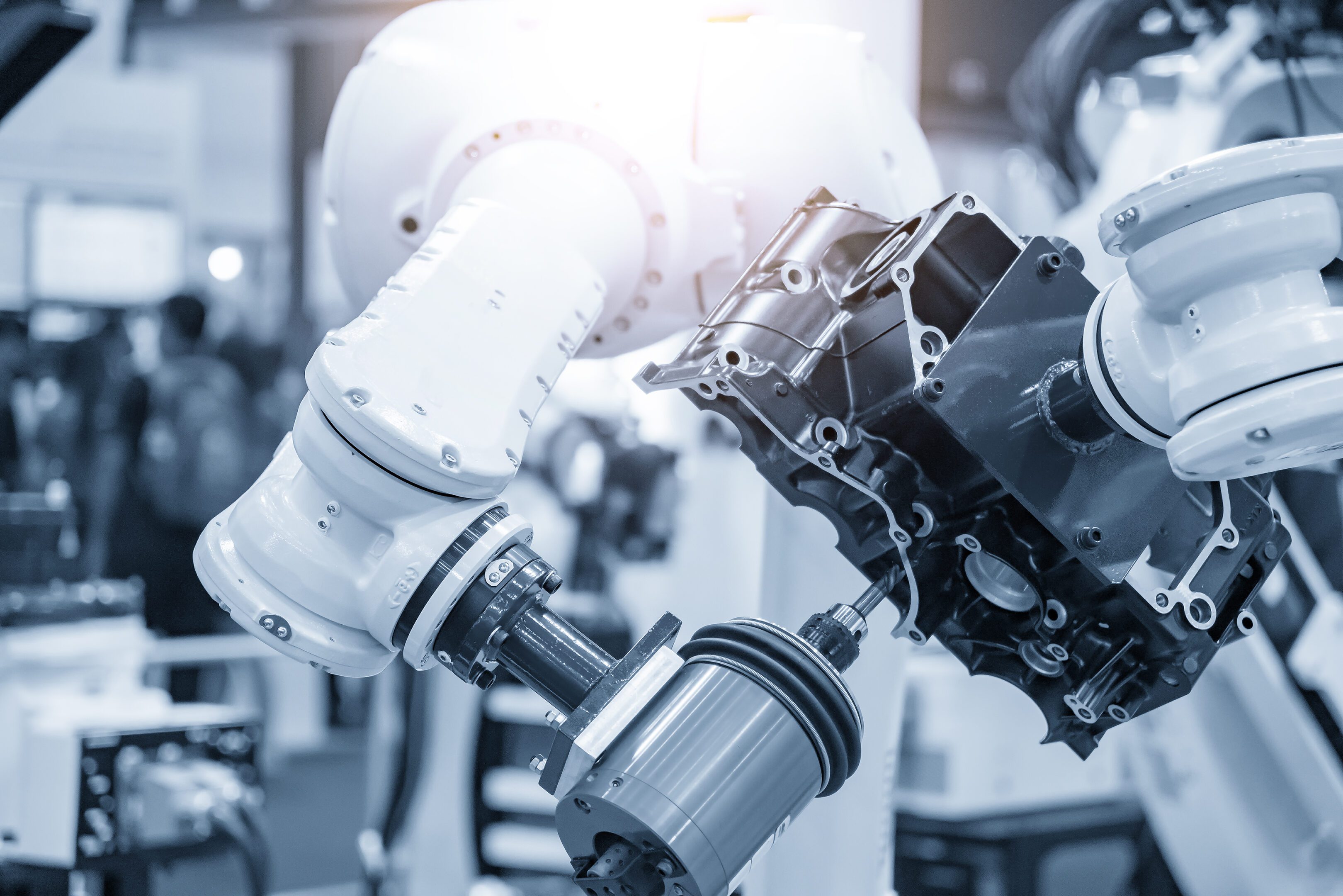Robotic arm assembling machinery in factory.