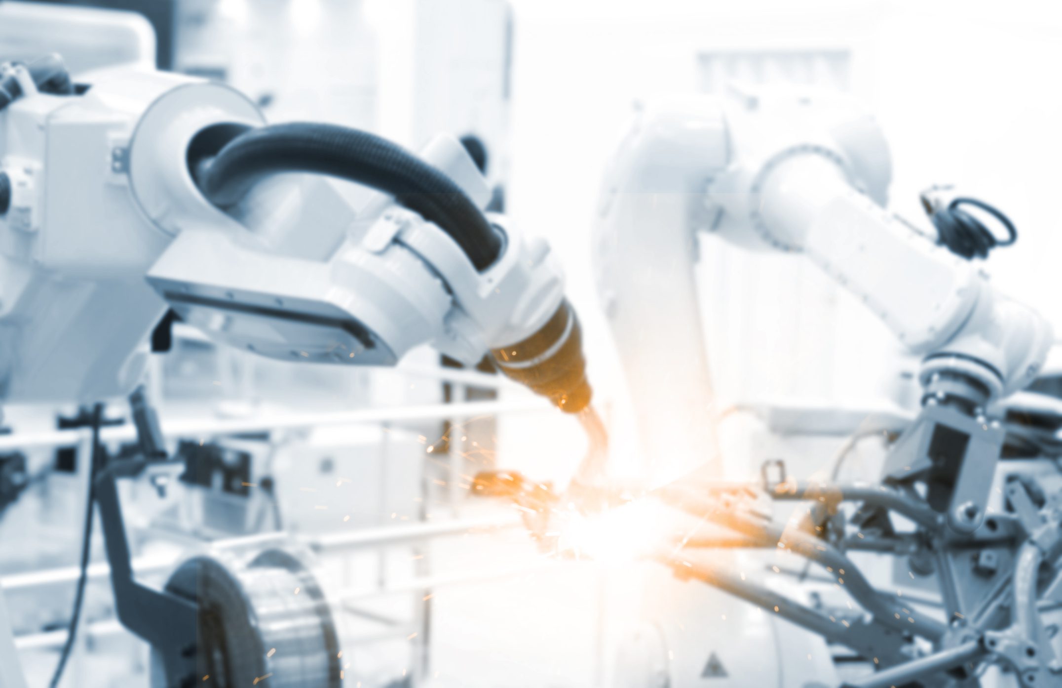 Robots welding in an industrial setting.